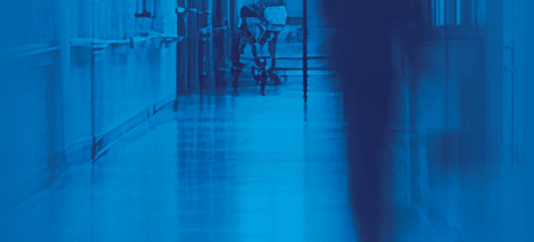 The Pitt title treatment with blurred hallway images in the background. - Banner