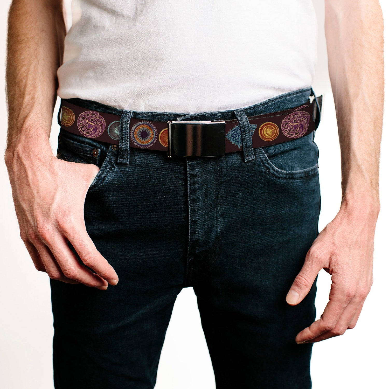 A person wears a white t-shirt, dark blue jeans, and a dark brown belt with round patterns and a silver buckle.